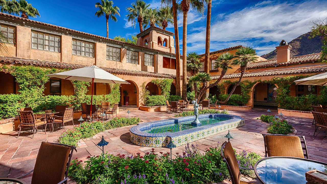 a courtyard with a fountain and palm trees