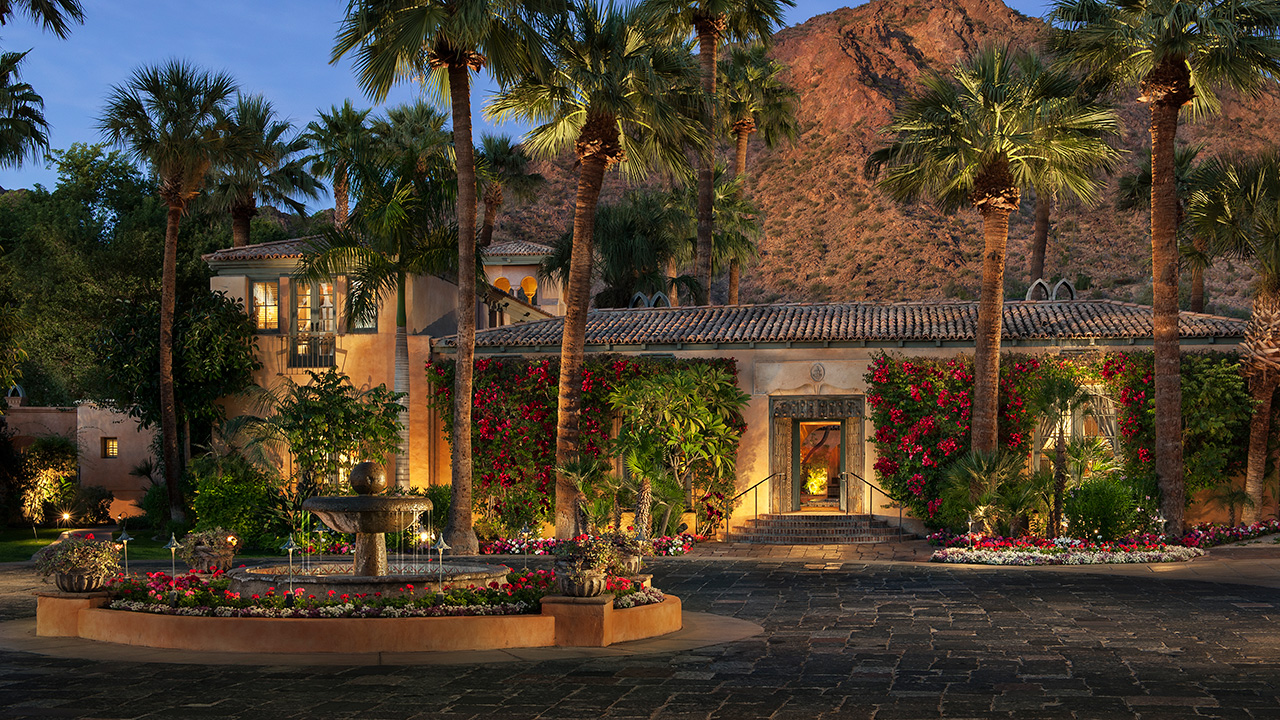a building with palm trees and a fountain
