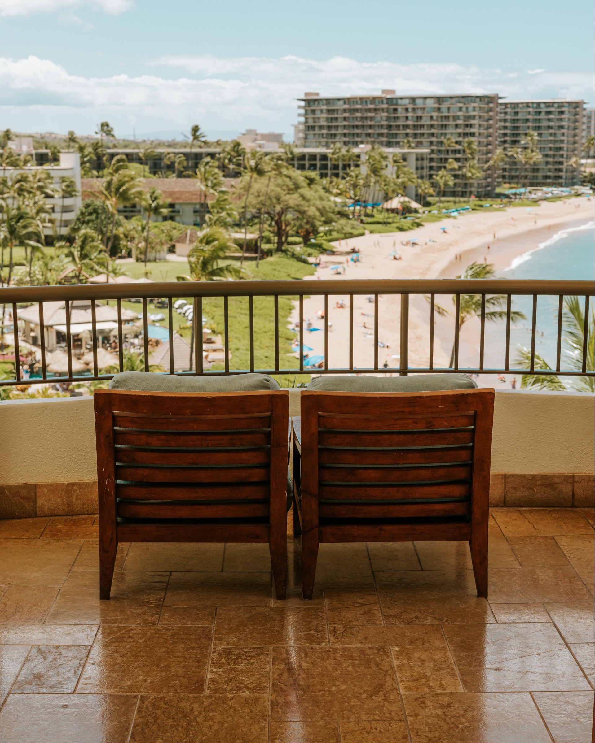 two chairs on a balcony overlooking a beach