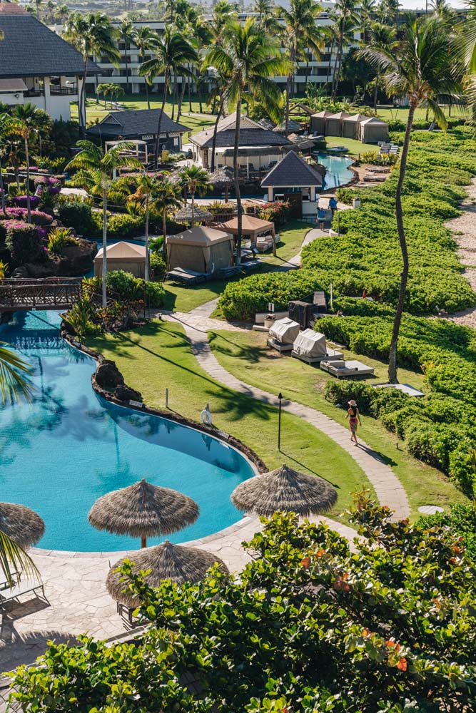 a swimming pool with huts and a beach