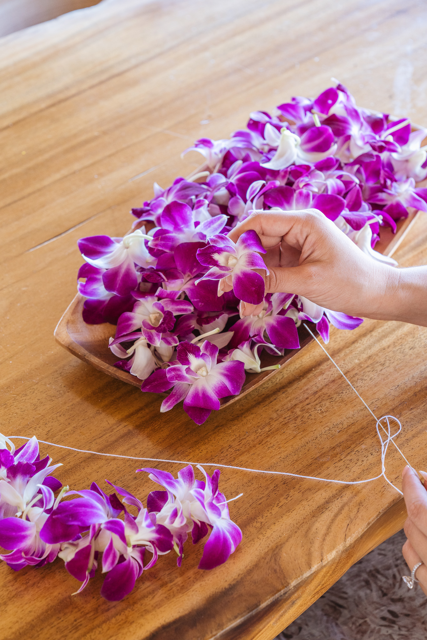 a person holding a string of purple flowers