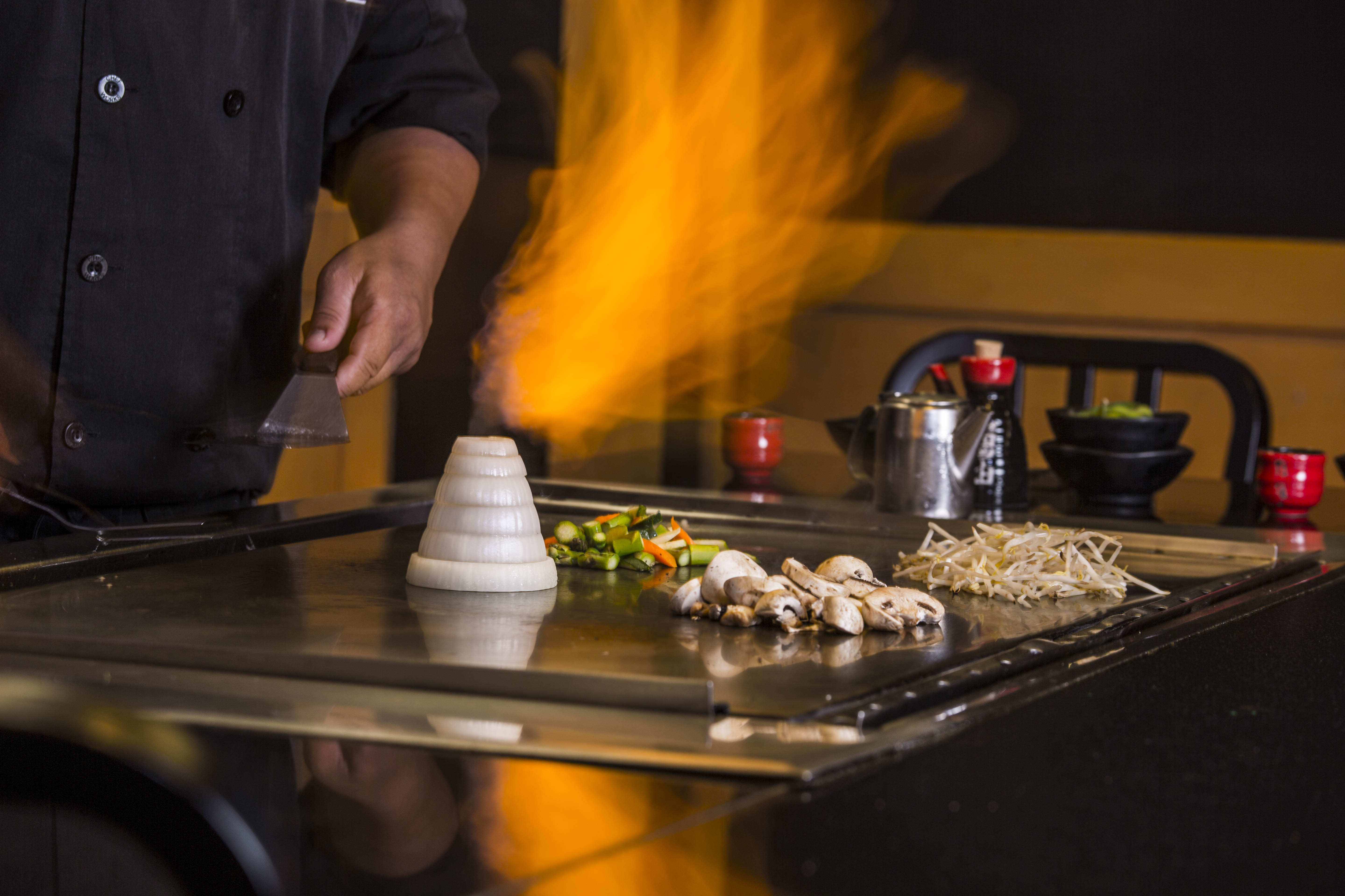 a chef cooking food on a grill