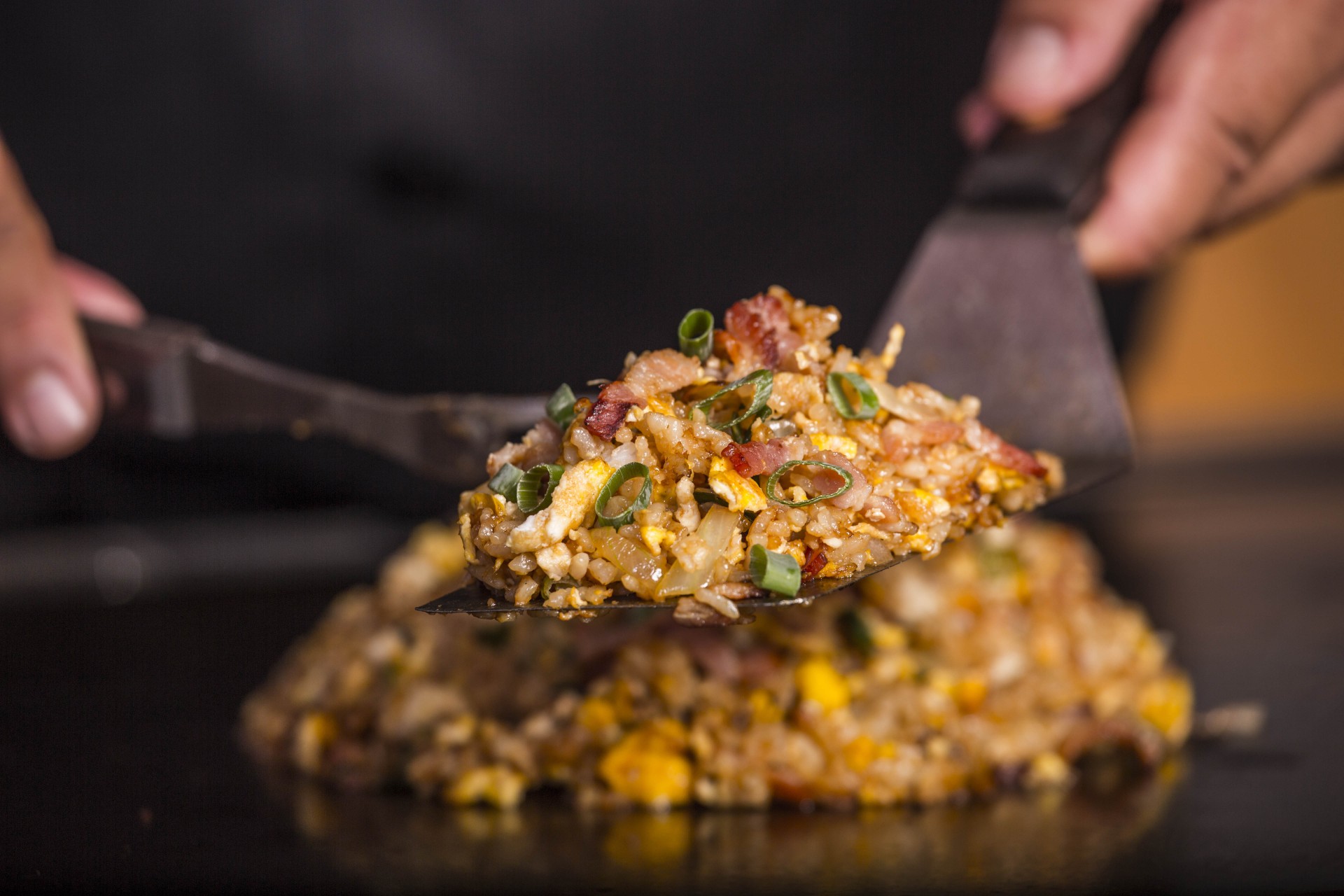 a person holding a spatula with food on it