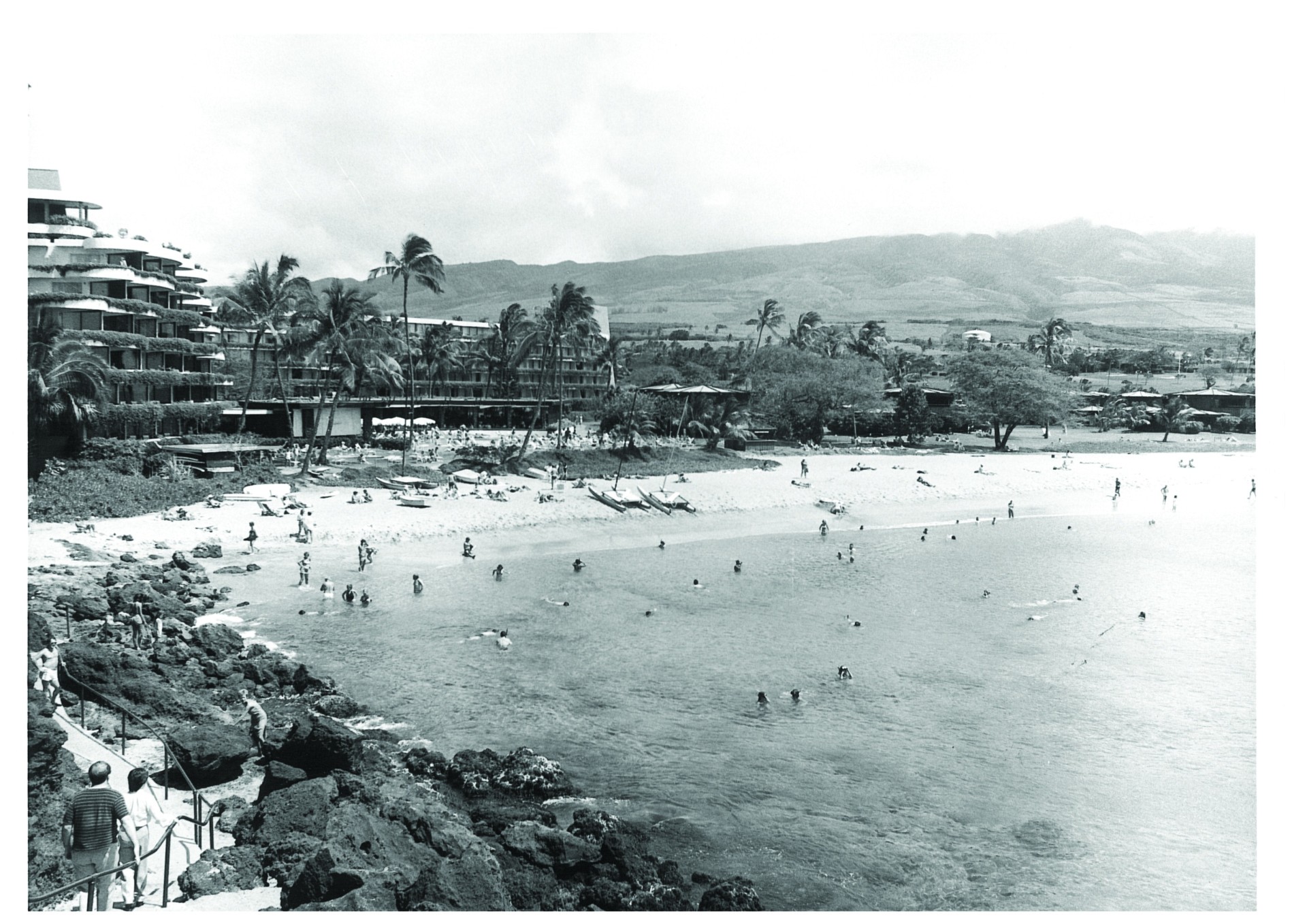 a black and white photo of people on a beach