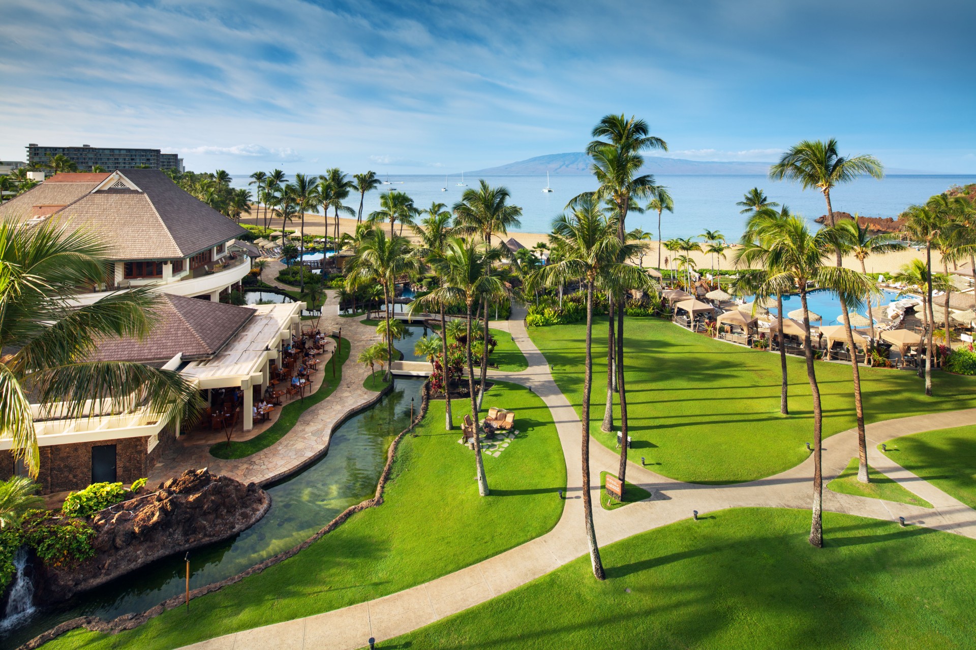 a resort with palm trees and a body of water