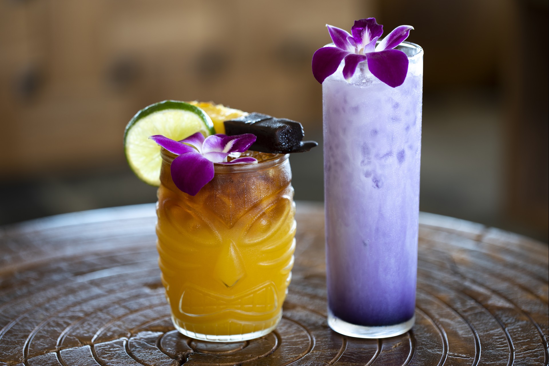 a glass with a drink and a purple drink with flowers