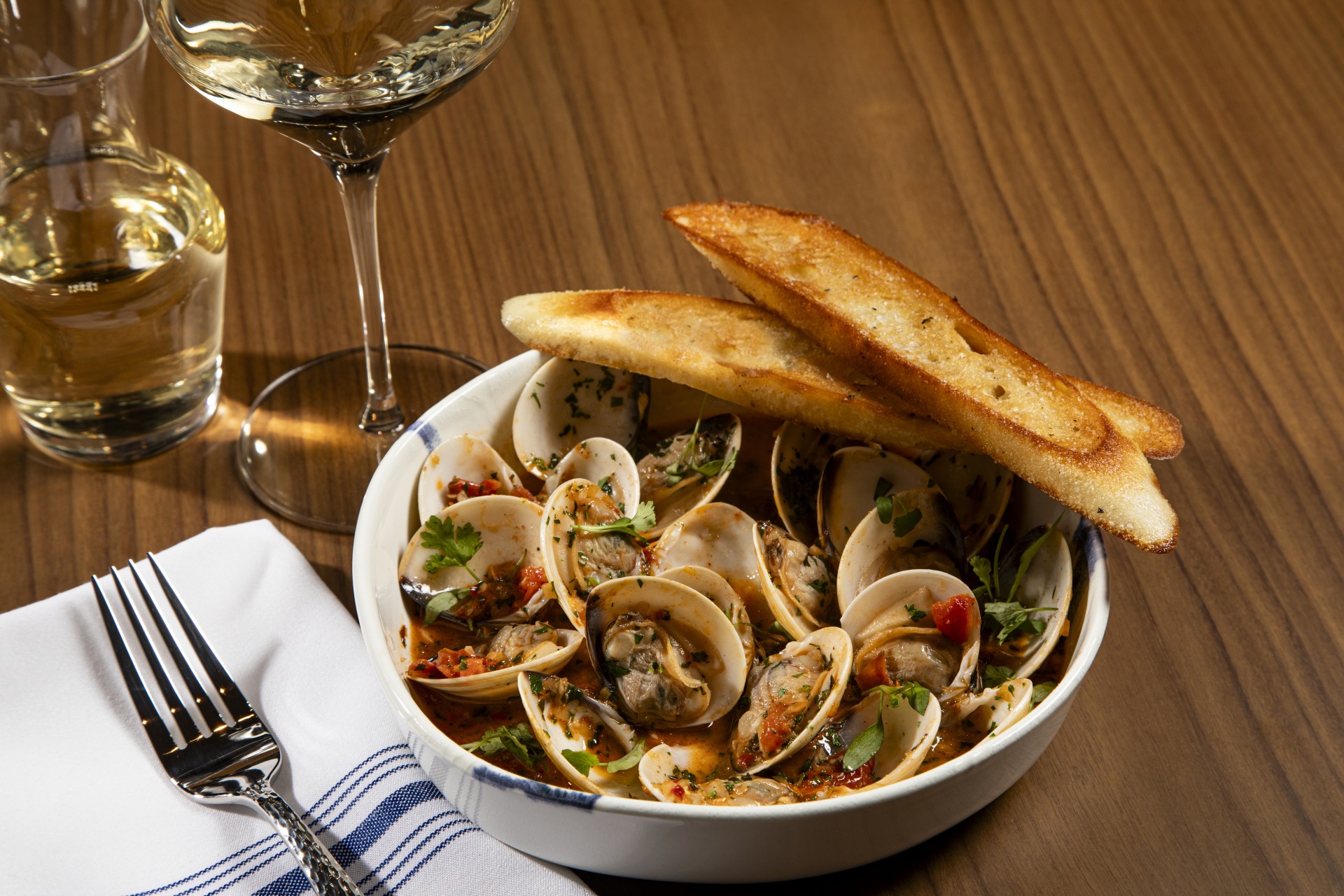 a bowl of clams and toasted bread