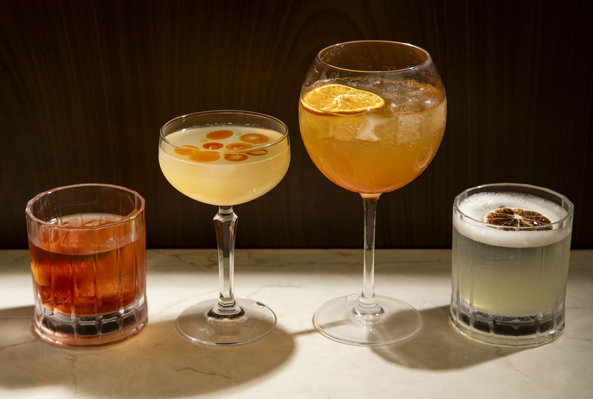 a group of glasses of different colored drinks