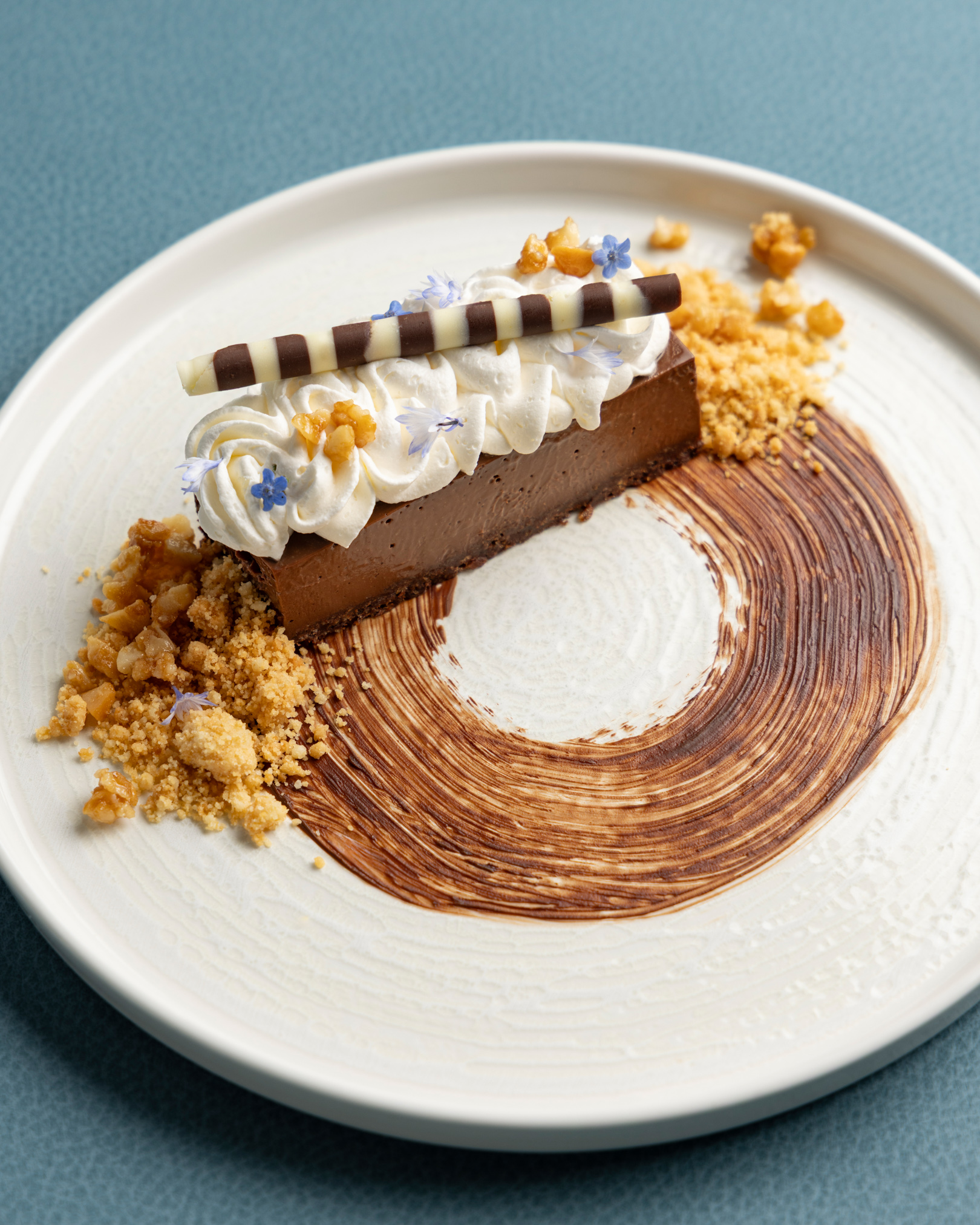 a piece of chocolate cheesecake with whipped cream and chocolate crumbles