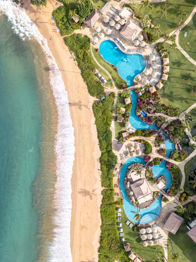 an aerial view of a resort with a pool and a beach