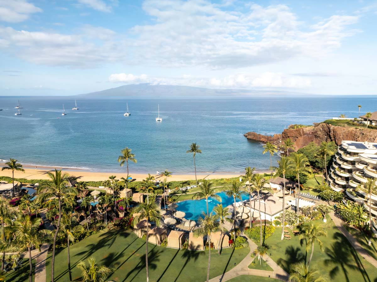 a resort with a pool and a body of water