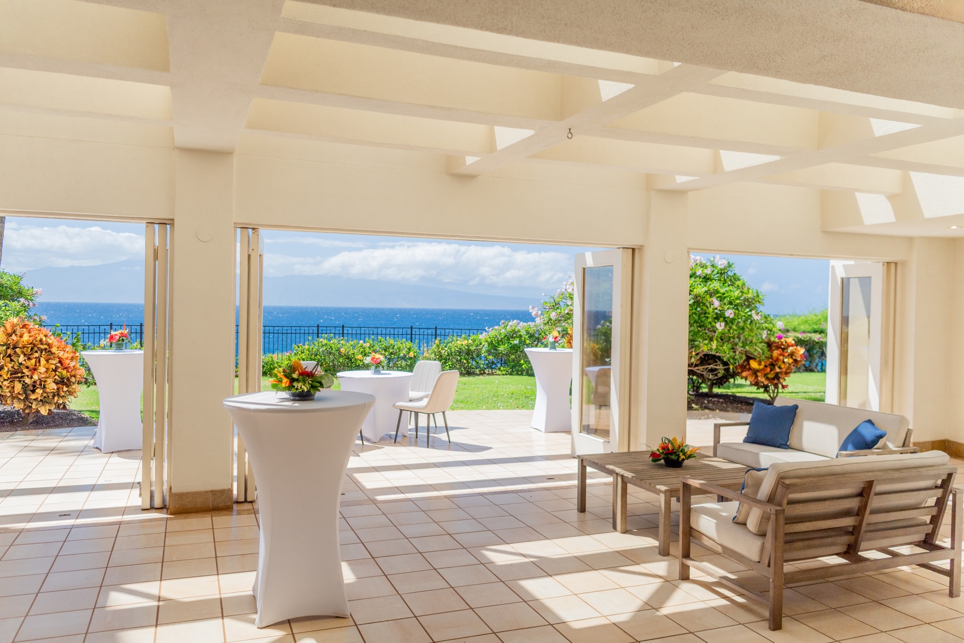 a patio with a table and chairs and a view of the ocean
