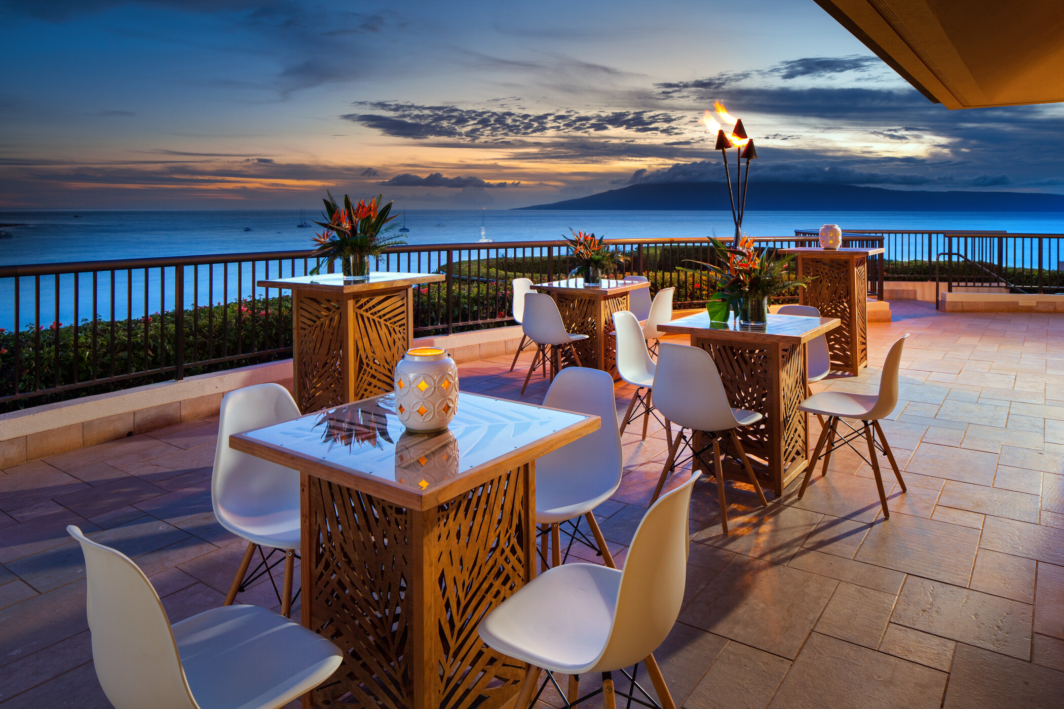 a table and chairs on a patio overlooking the ocean
