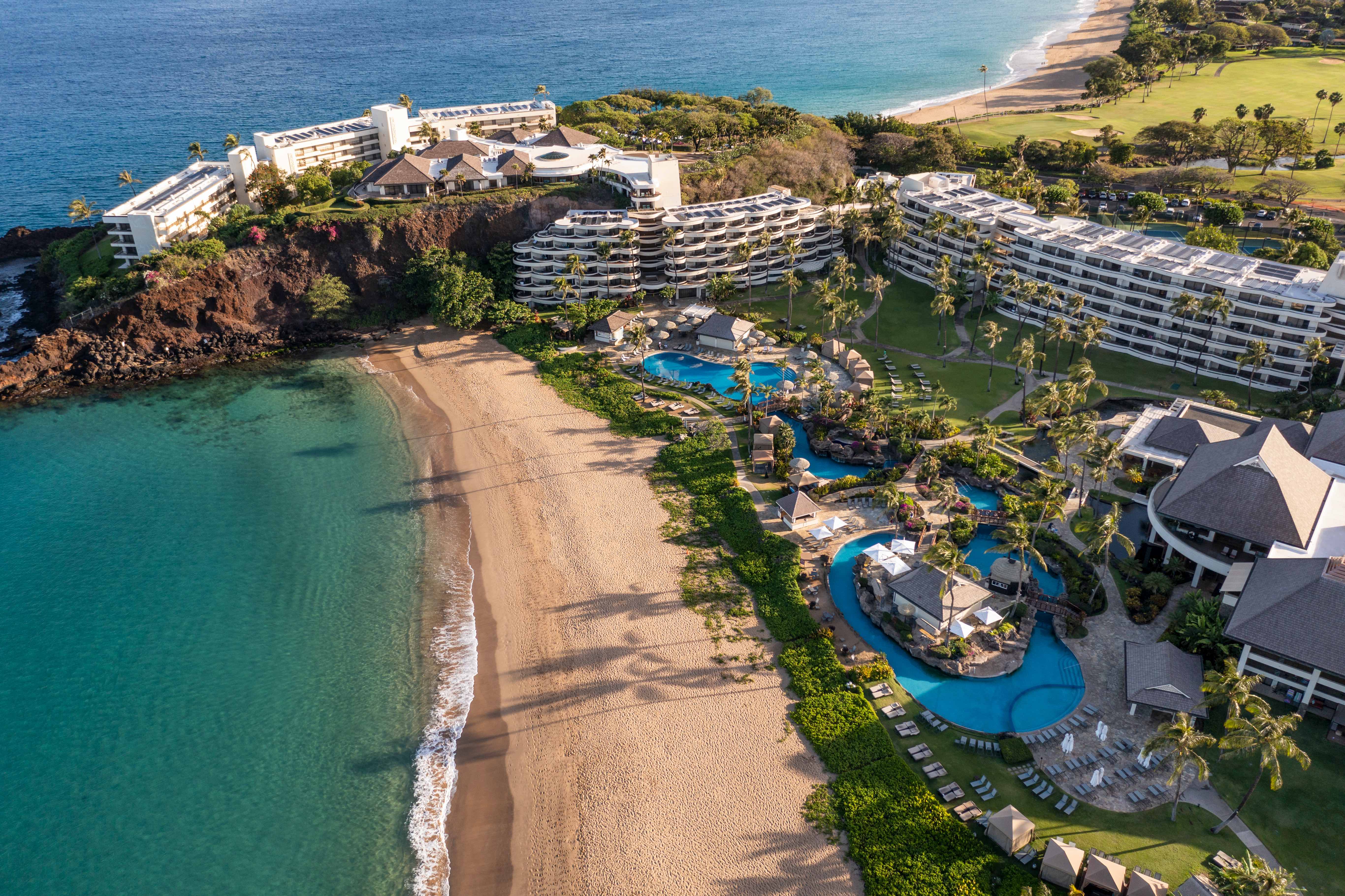 a beach with a group of buildings and a pool