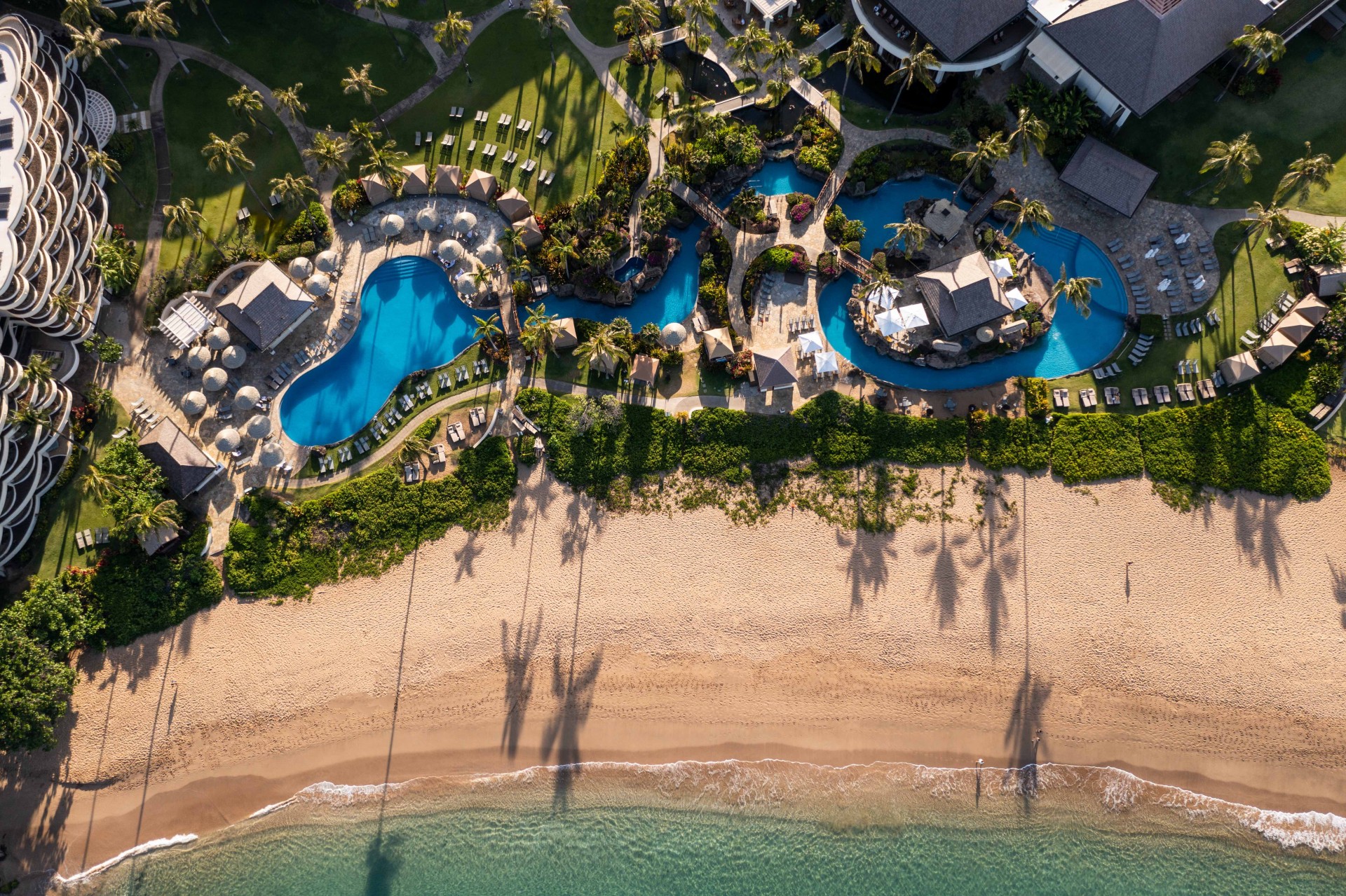 a aerial view of a resort with swimming pools and a beach