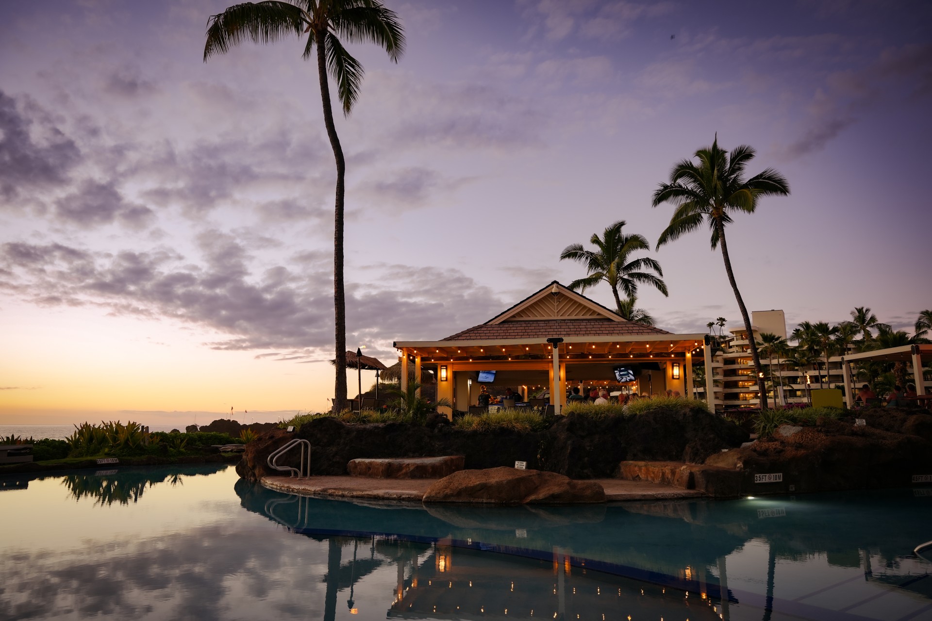a pool with a building and palm trees