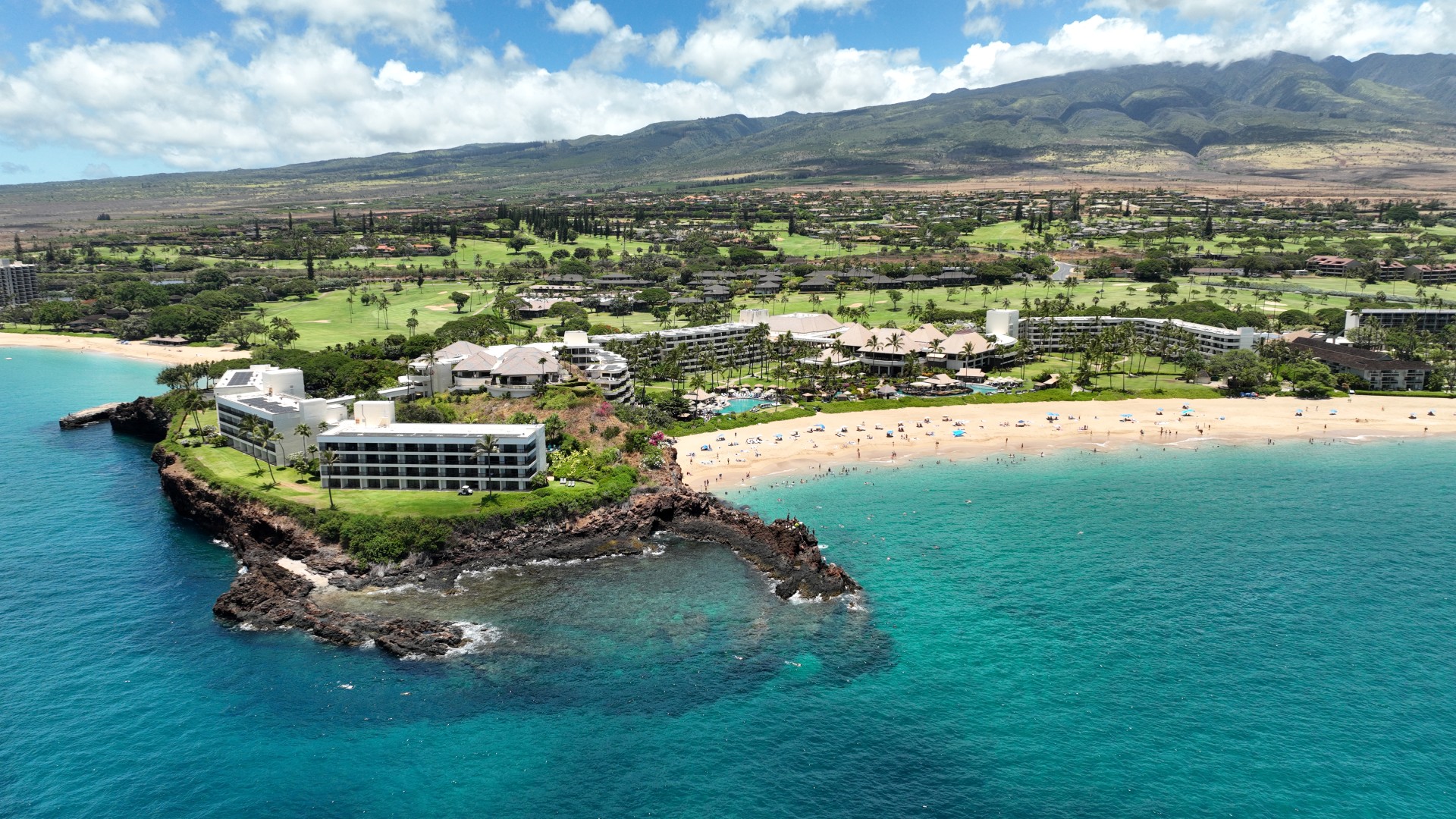 a beach with buildings and a body of water