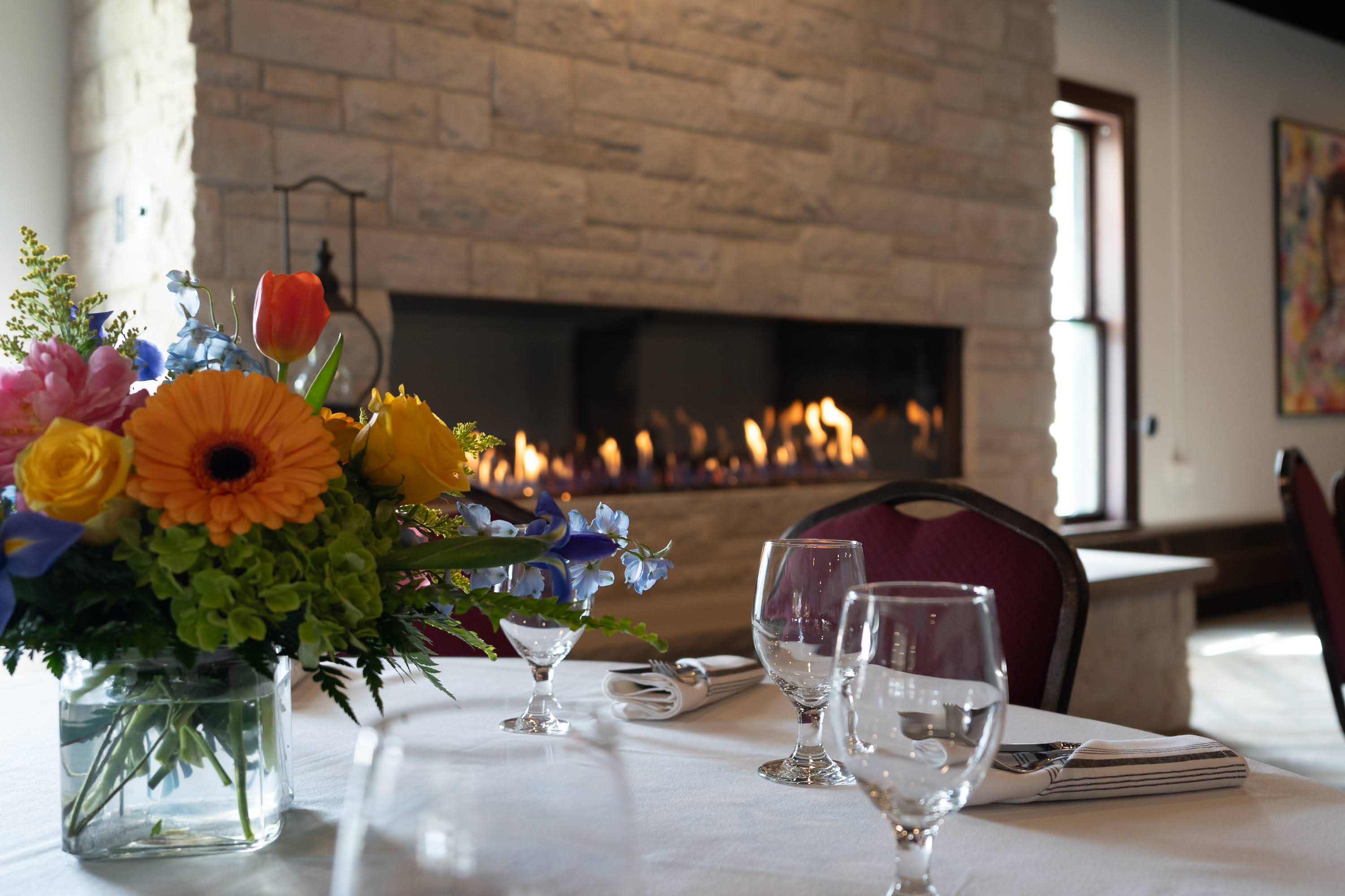 a table with flowers and wine glasses