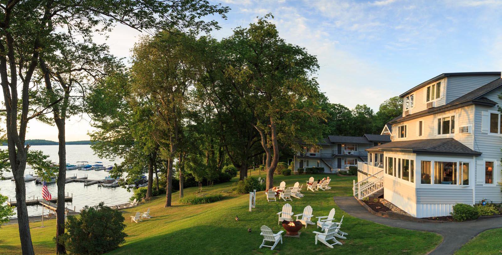 a lawn with chairs and a fire pit in front of a house