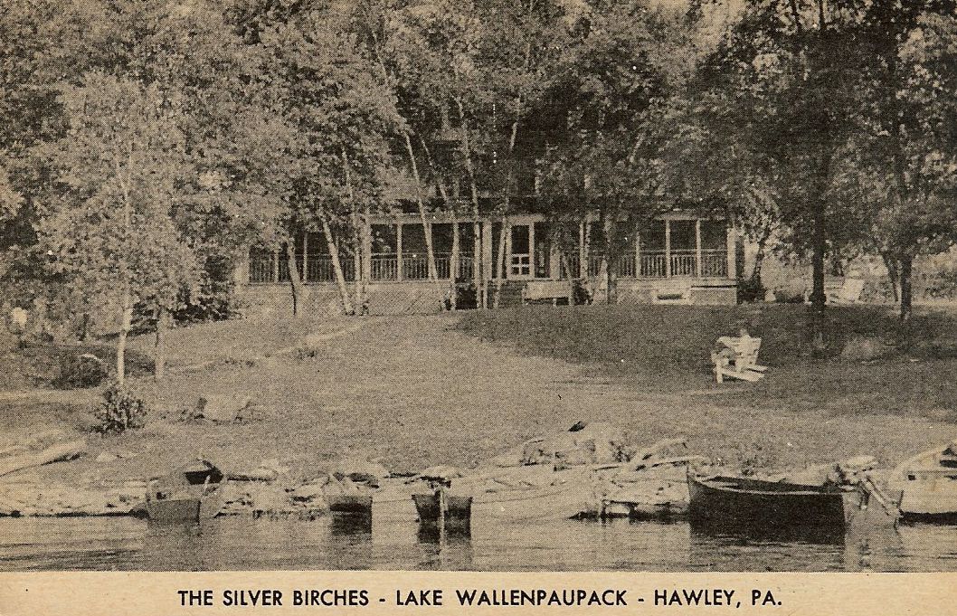 a house with trees and a lake