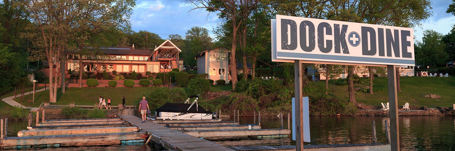 a sign on a dock with a boat in the water