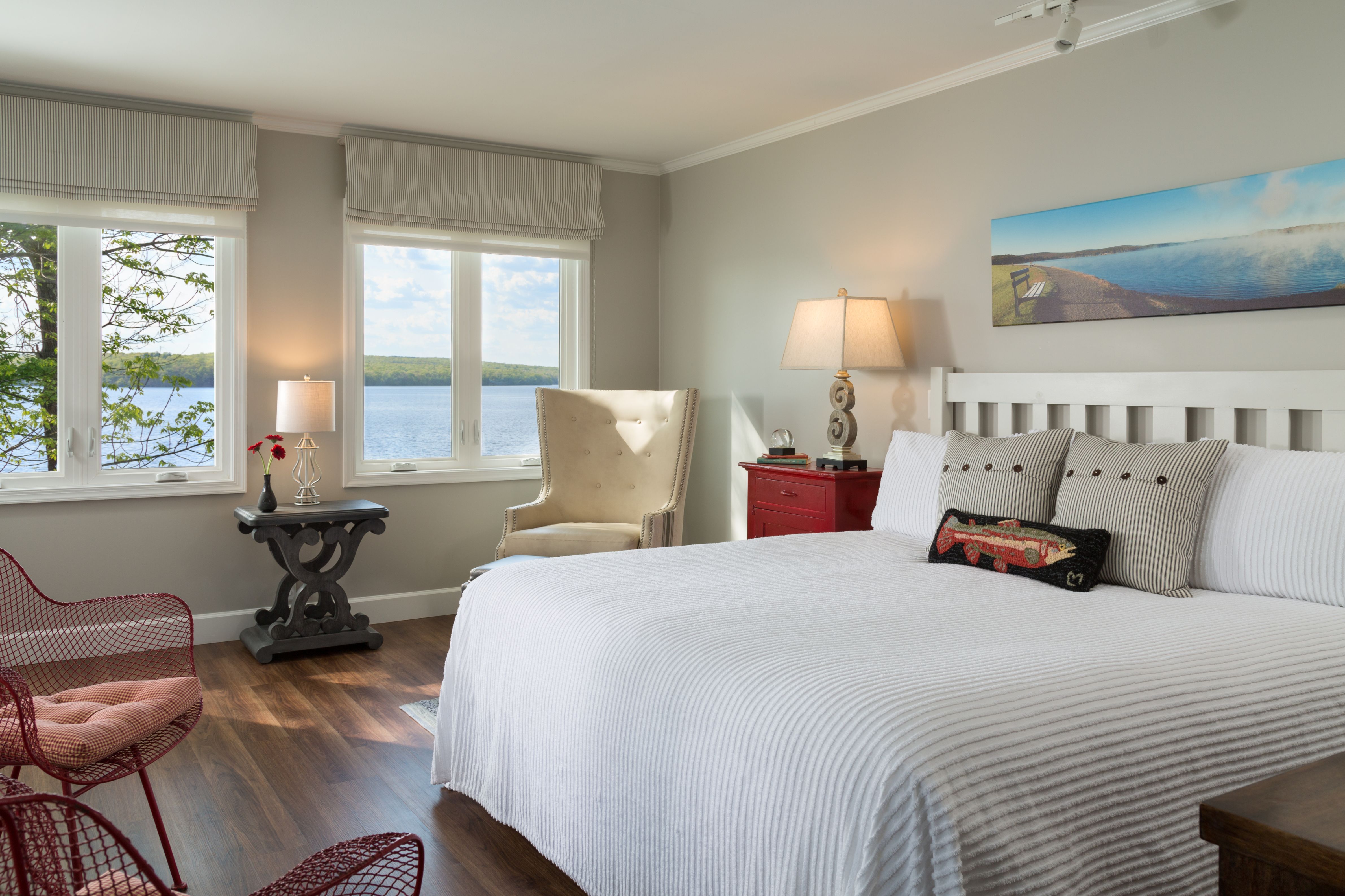 a bedroom with a large bed and a chair and a window