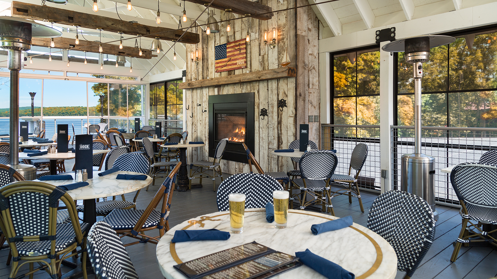 a room with tables and chairs and a fireplace