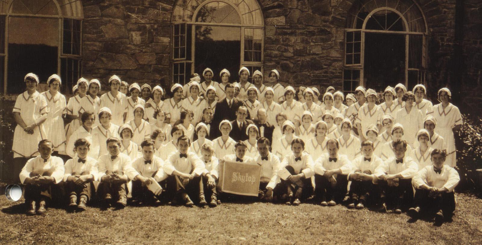 a group of people in white uniforms posing for a photo