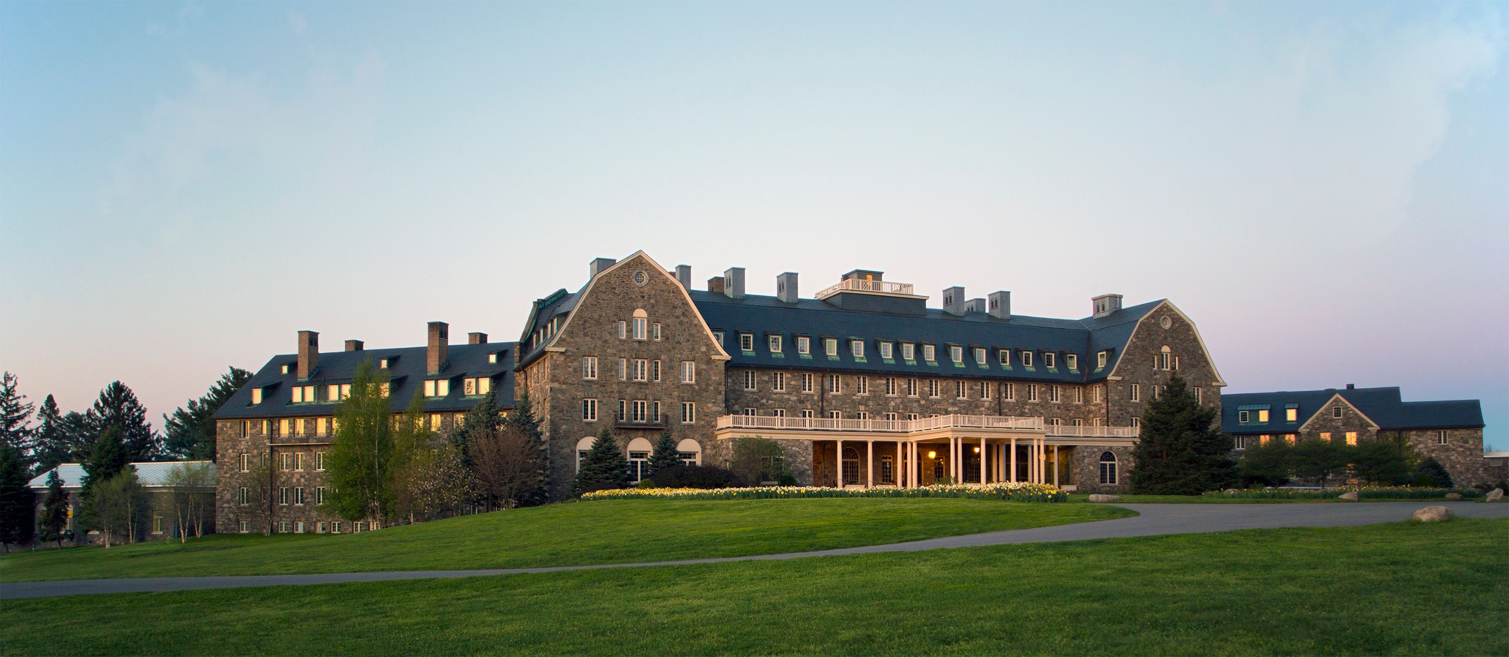 a large stone building with a lawn and grass