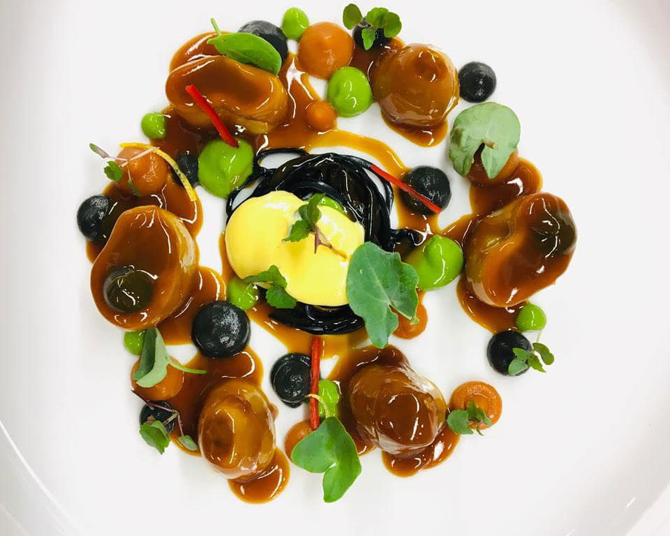 a plate of food with sauce and leaves