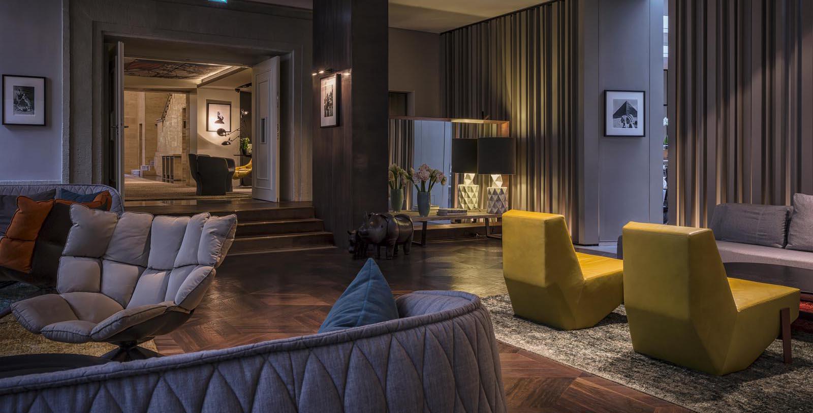 a living room with a yellow couch and a black lamp