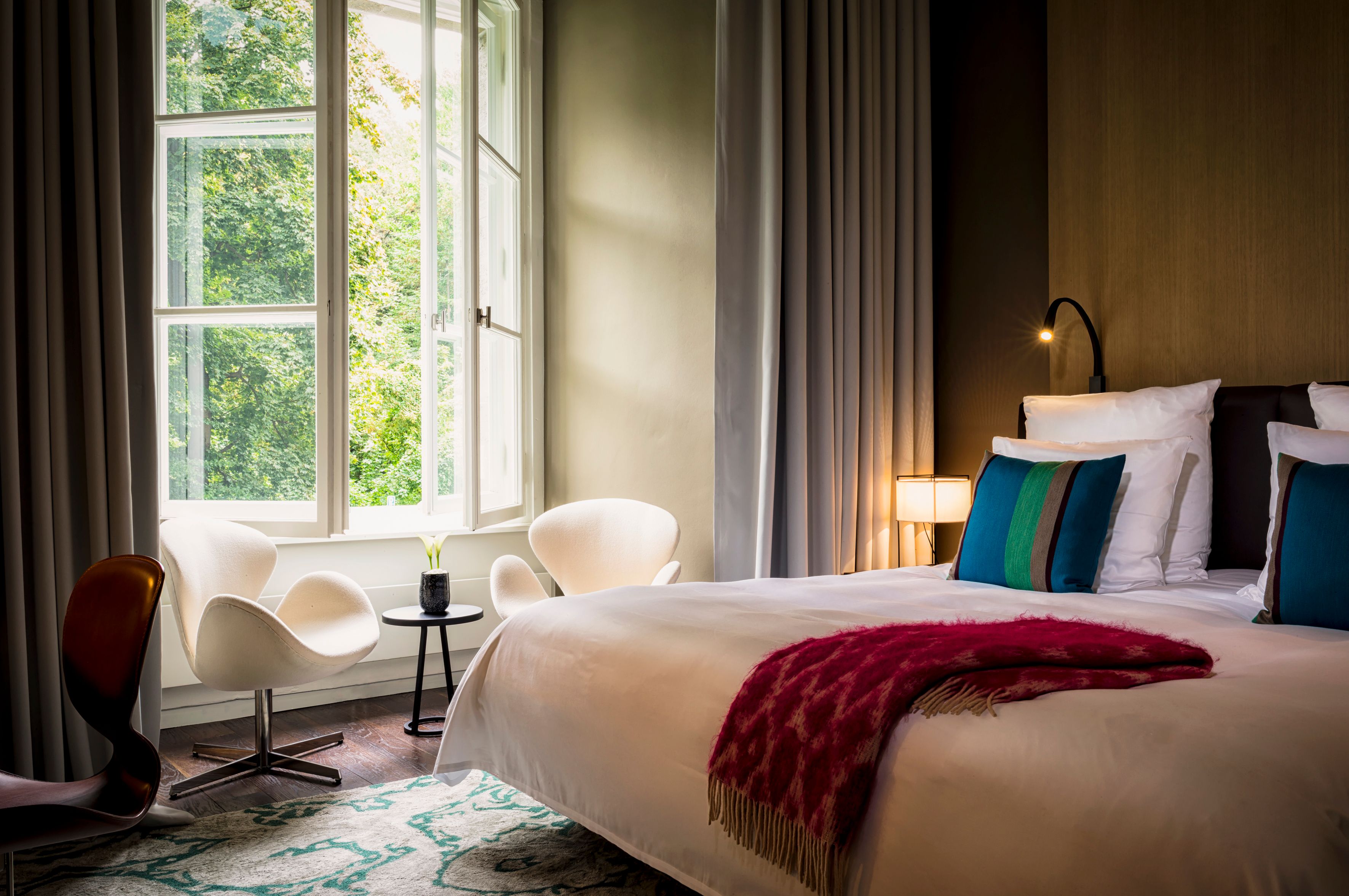 a bedroom with a bed and chairs