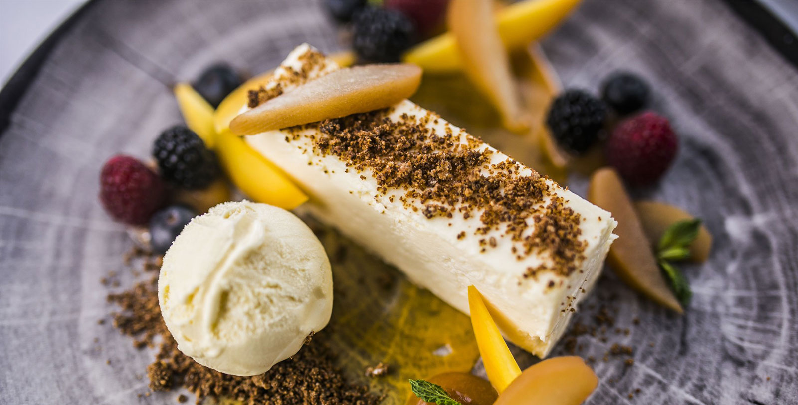a white cake with fruit and ice cream on a plate