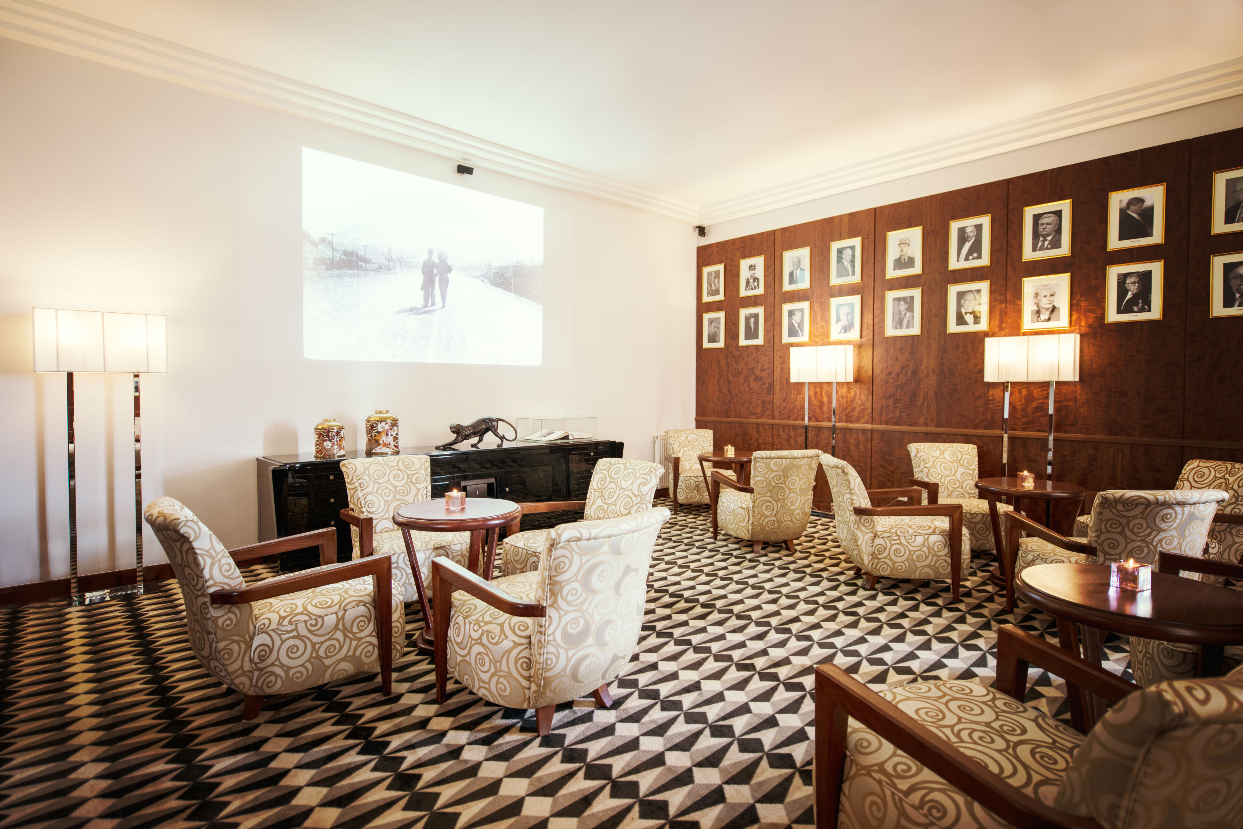 a room with chairs and a black and white patterned carpet