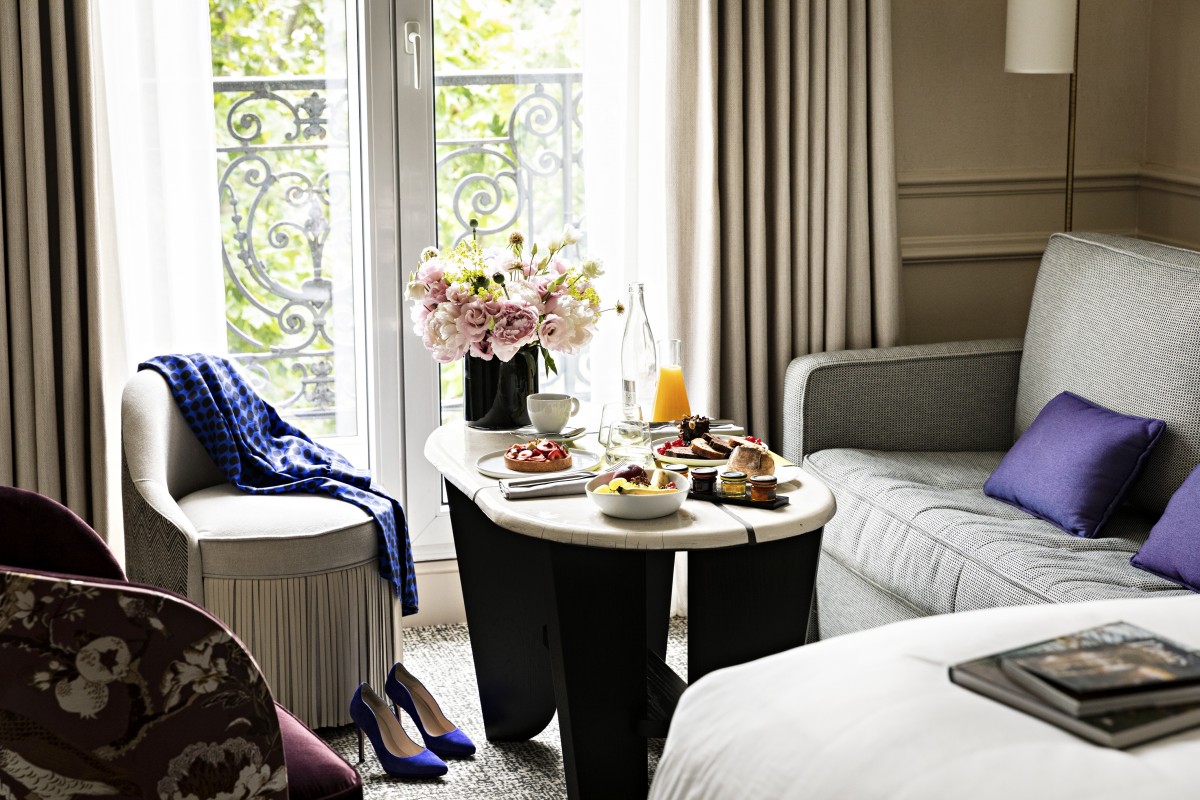 a table with food on it and a vase of flowers in front of a window
