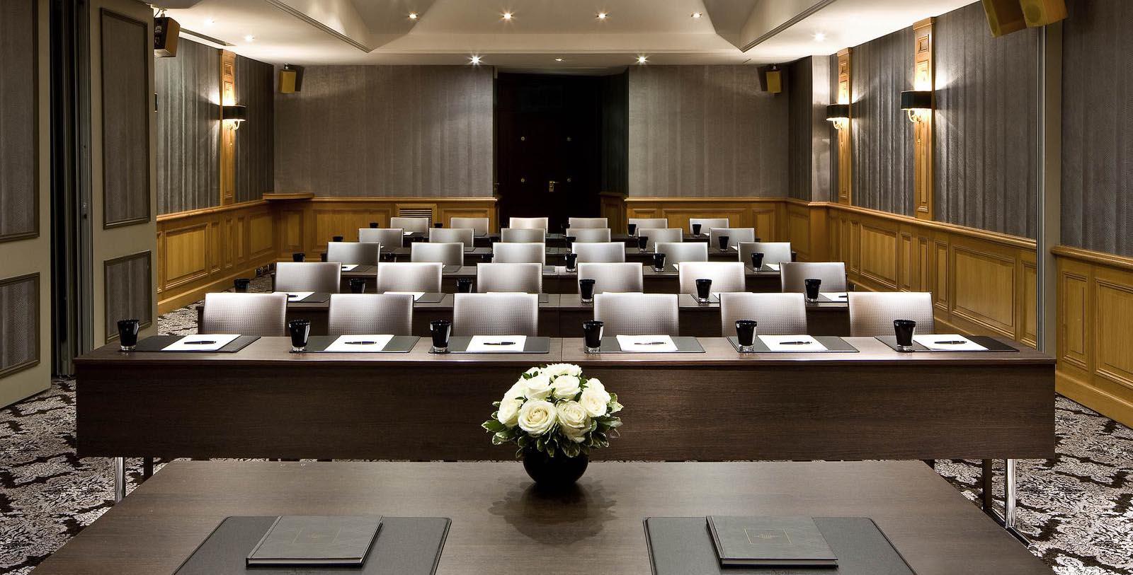 a room with chairs and a vase of flowers