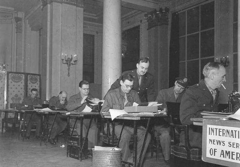 a group of men in military uniforms sitting at desks