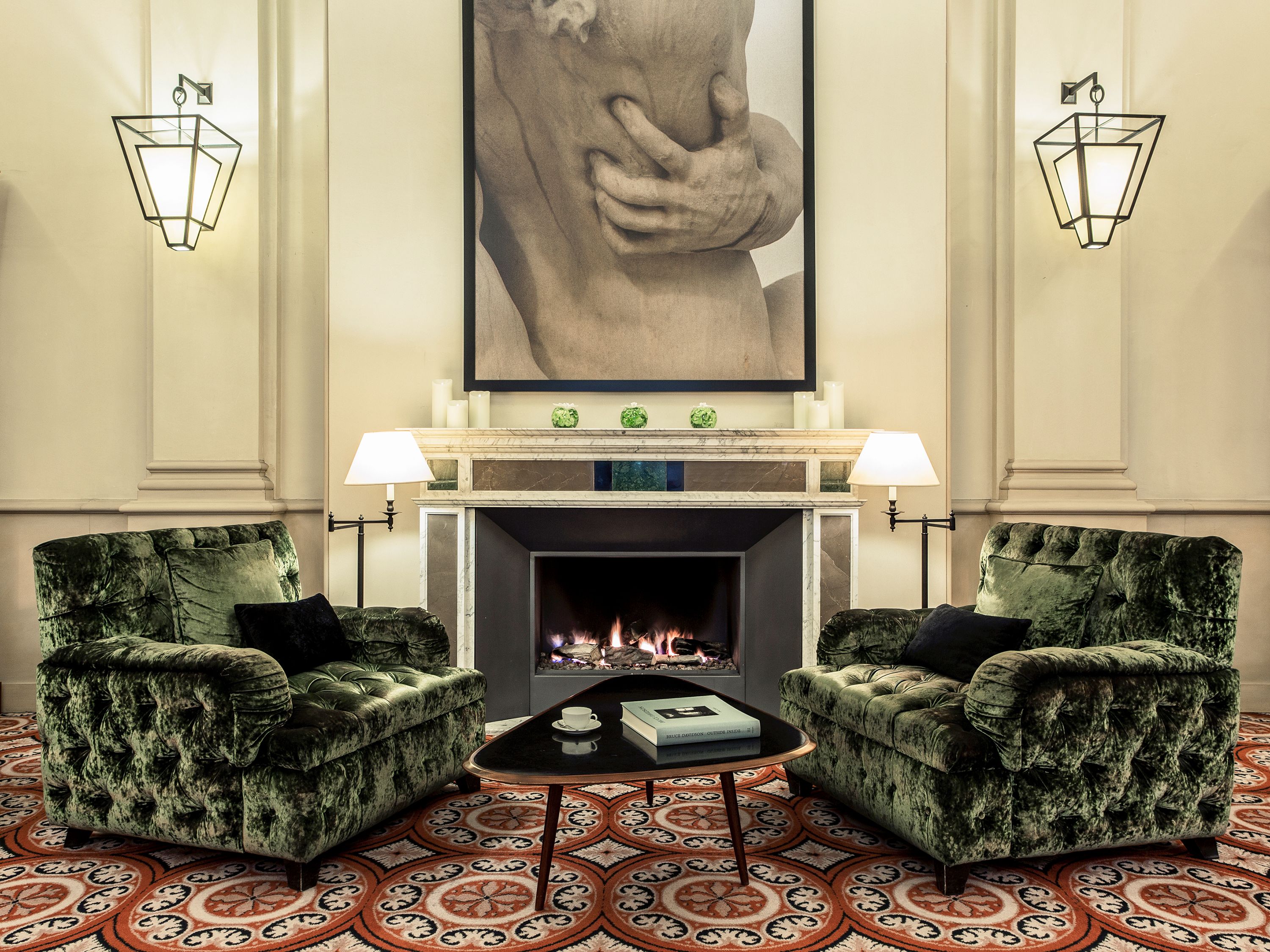 a room with a fireplace and green chairs