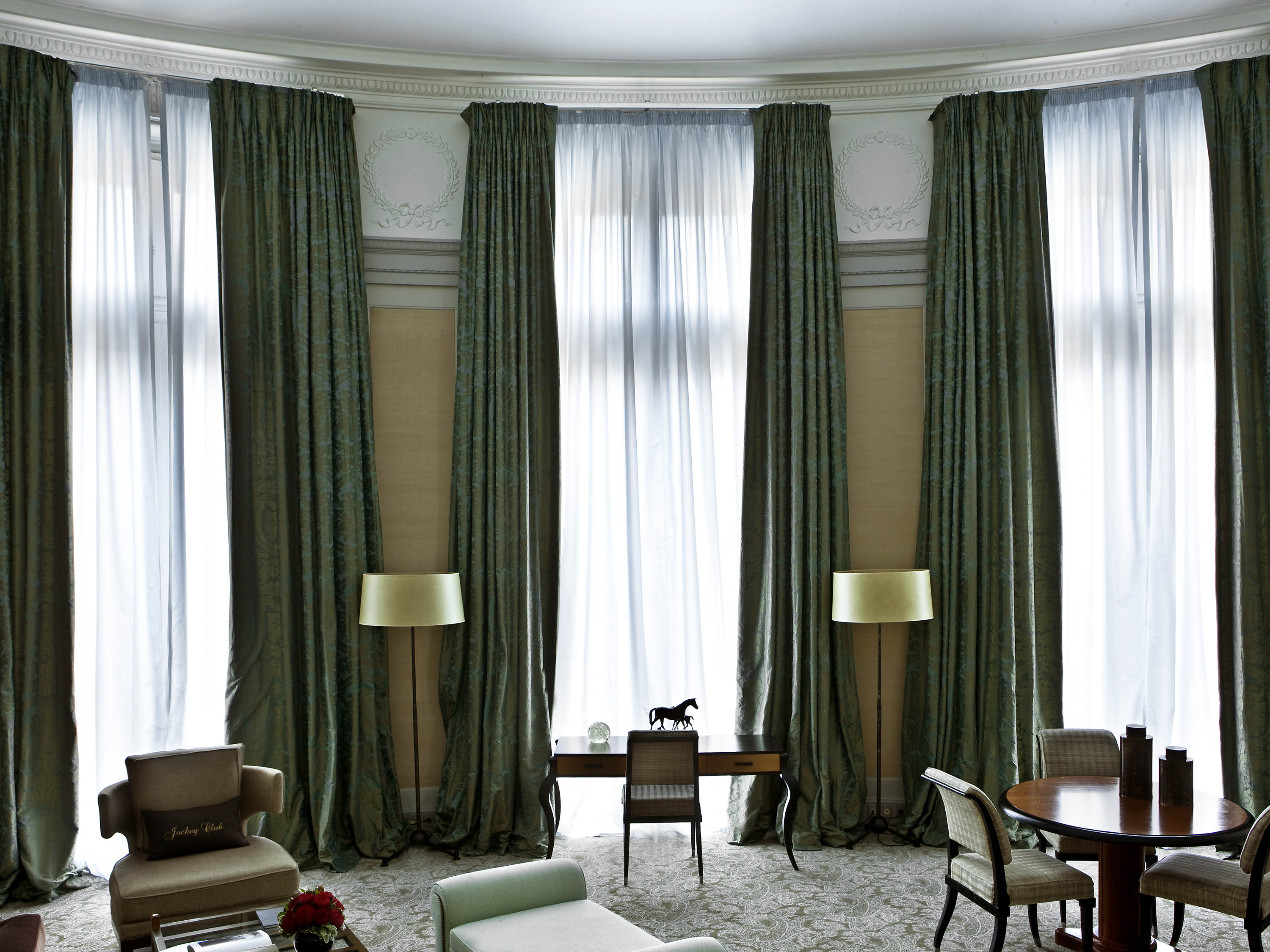 a room with green curtains and a table