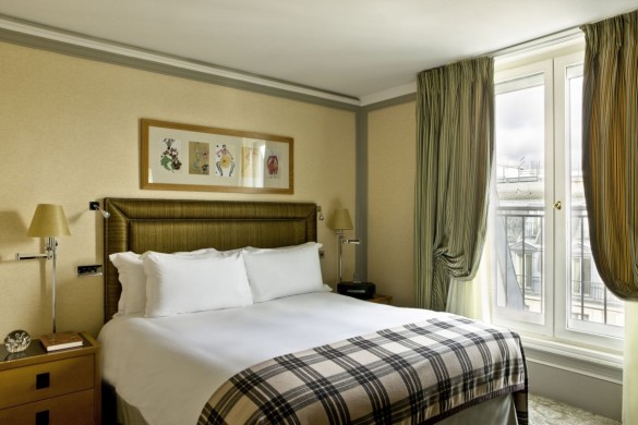 a bed with a plaid blanket and a window
