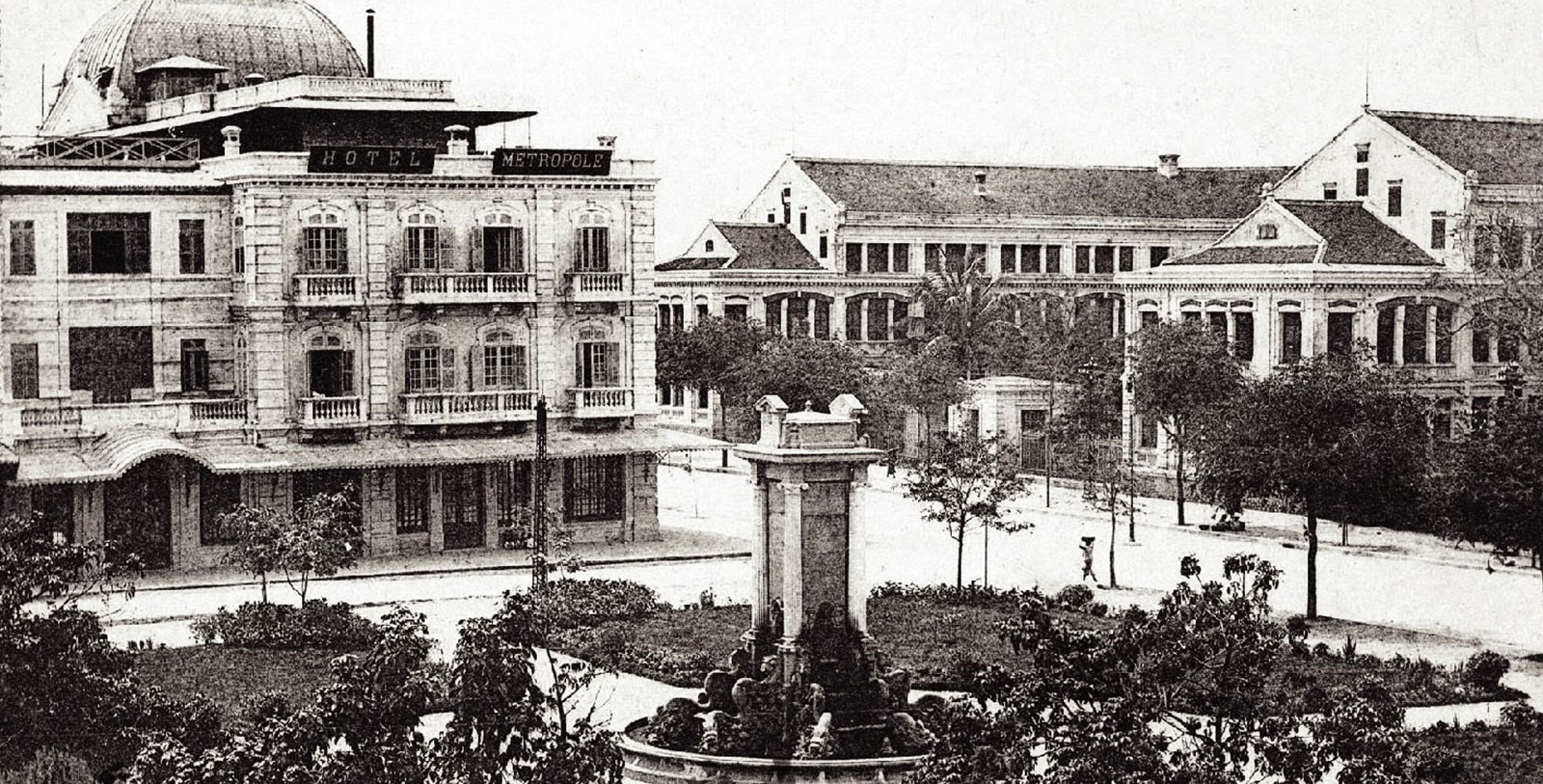 a fountain in a park with buildings in the background