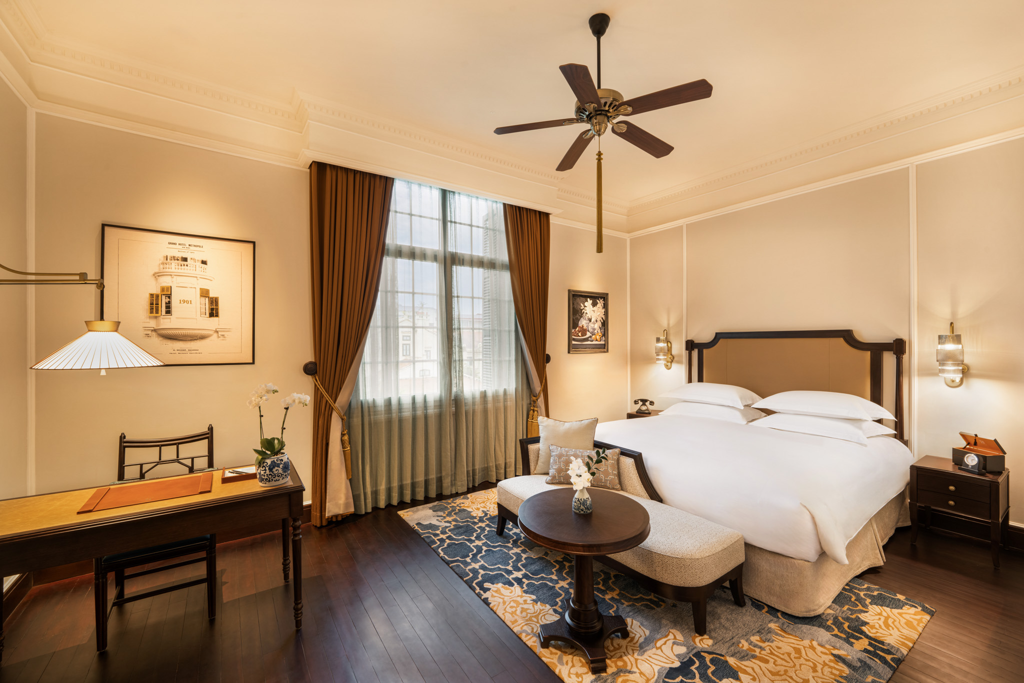 a room with a bed and a table and a fan