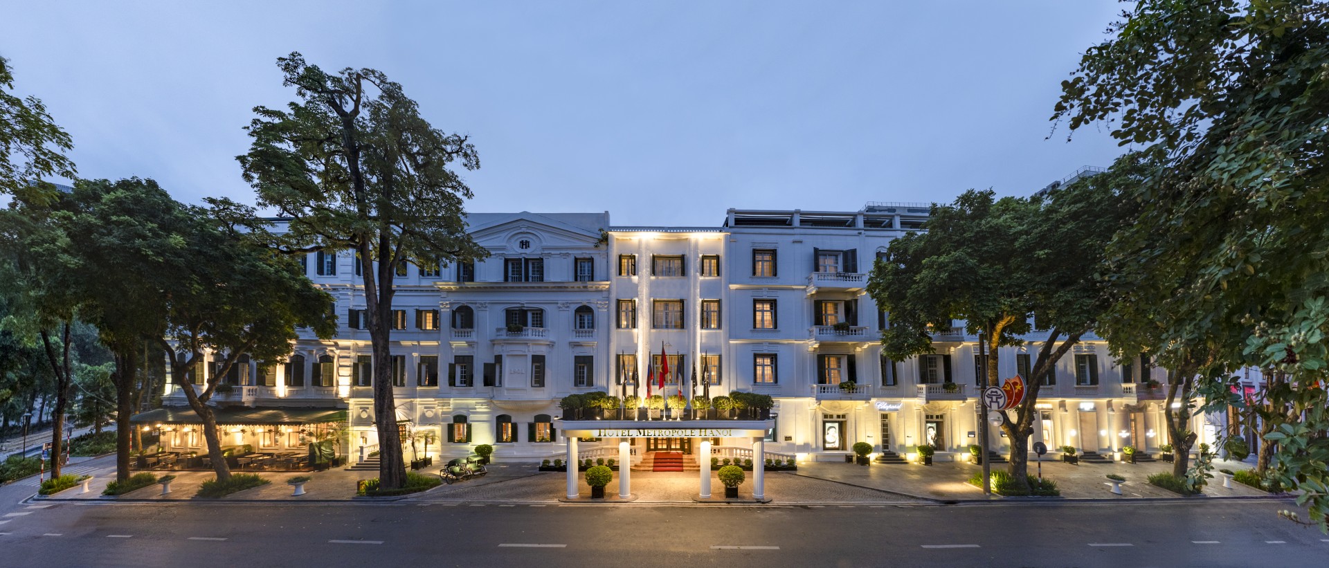 a large white building with flags and columns