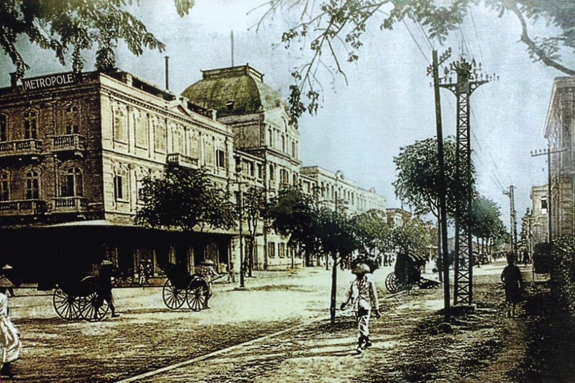 a man walking on a street with a horse carriage and people