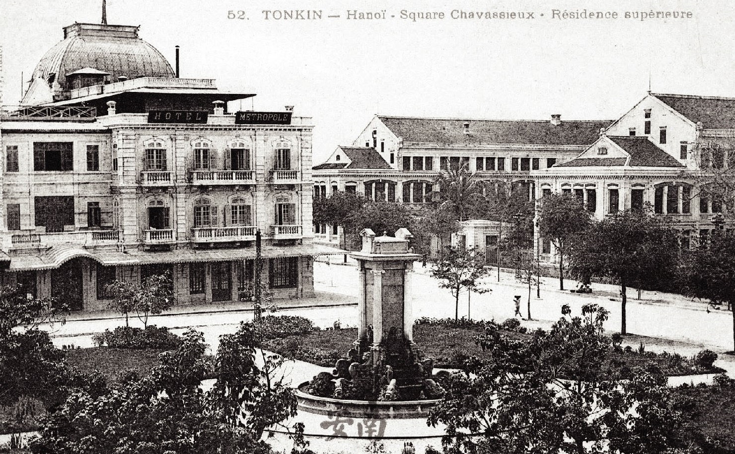 a fountain in a park with buildings in the background