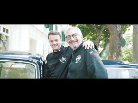 two men standing next to a car