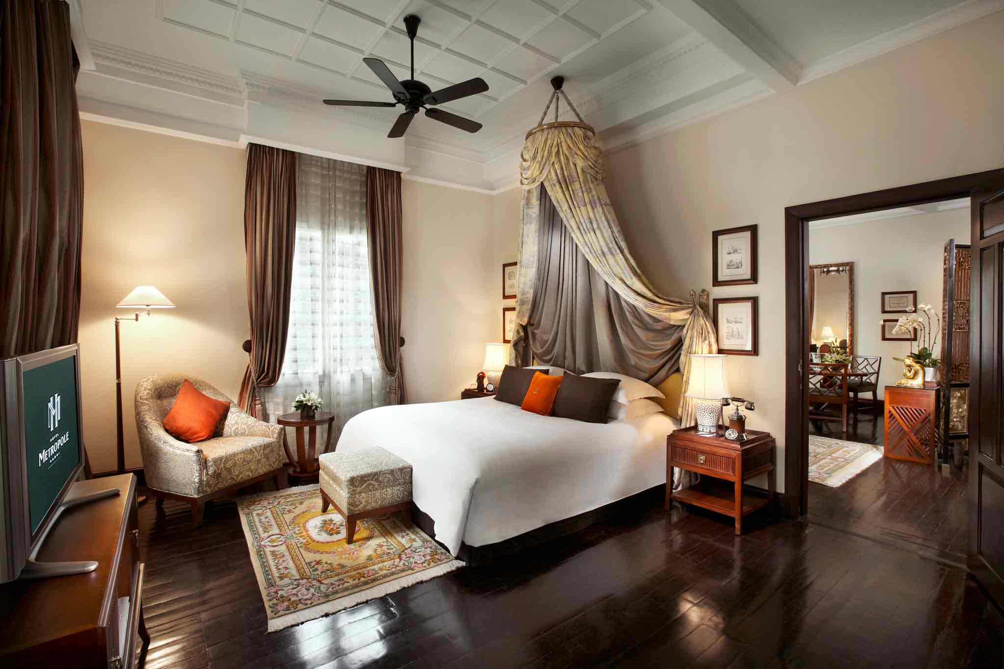 a room with a bed and chairs