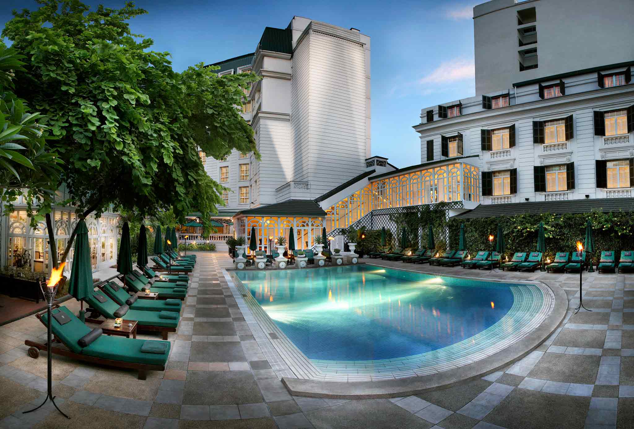 a pool with lounge chairs and a building