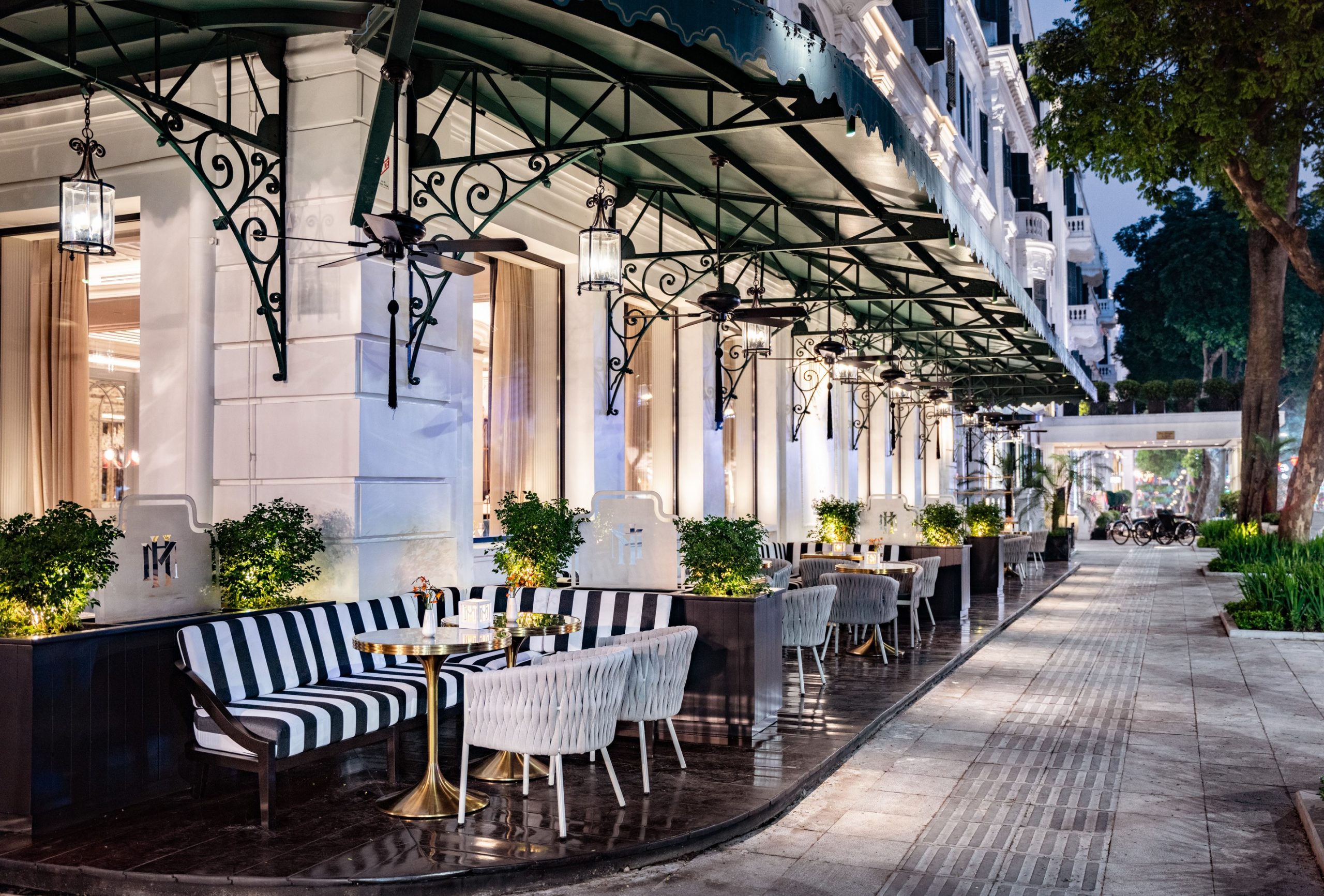 a sidewalk with tables and chairs