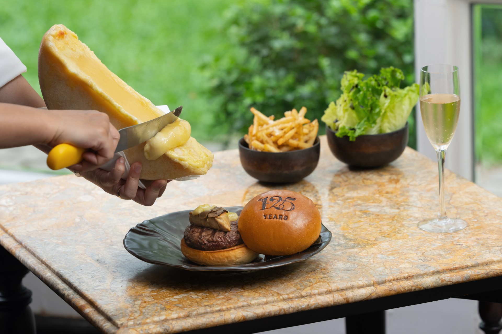a person spreading cheese on a plate of food